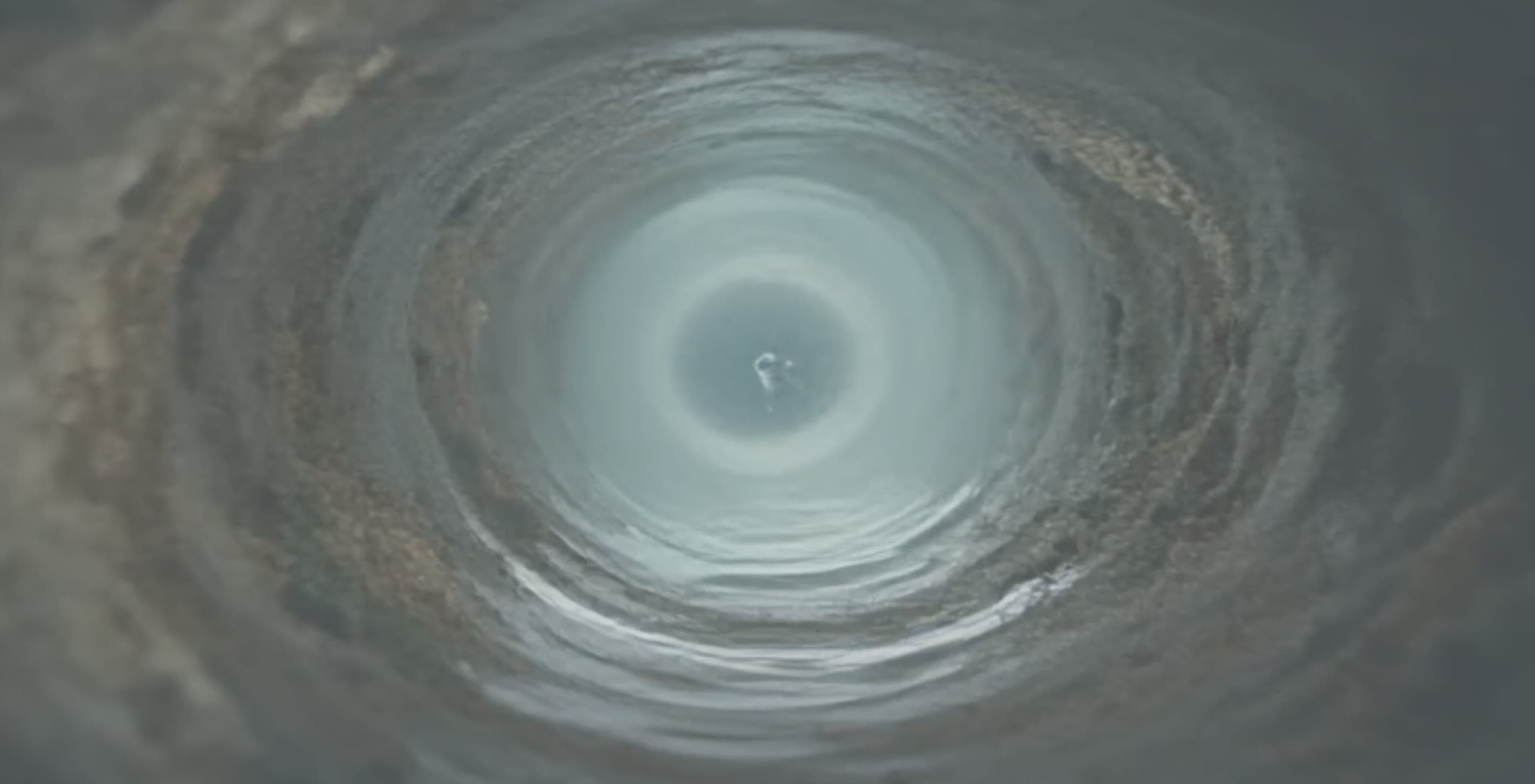 MERUS: water spiralling inside a pipe, still from the MERUS film.