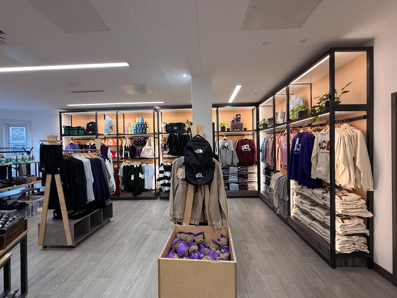 A store aisle with clothing racks.